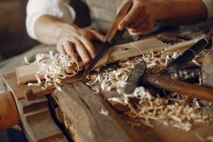 Main d'un artisan qui travaille le bois à l'aide d'outils. Trousse de secours artisan