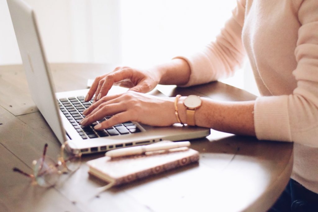 Femme sur l'ordinateur effectuant une démarche de changement d'adresse de carte grise